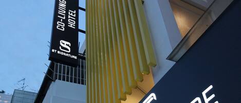 A hotel sign with the name "St. Signature" and "Co-Living Hotel Bugis Beach".