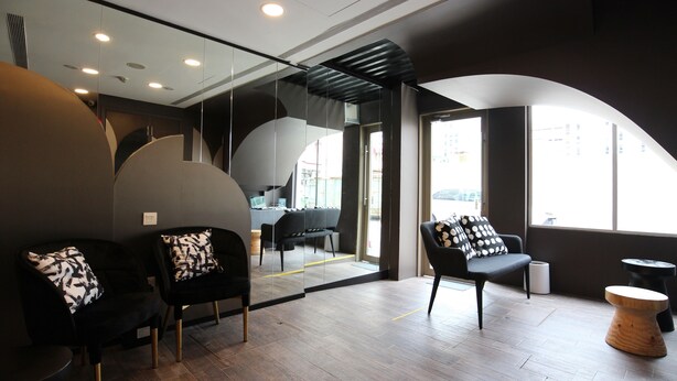 A modern interior with black and white chairs, a wooden stool, and a glass partition. - ST Signature Bugis Beach, SHORT OVERNIGHT, 12 hours: check in 7PM or 9PM (Singapore)