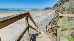 Eine Holztreppe führt zu einem Strand mit freiem Blick auf das Meer.