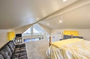 A bedroom with a large bed, a sofa, a television, and a balcony with a view. - Peaceful Fall Escape: Oregon Home w/ Ocean View (Florence)