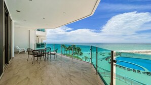 Un balcón con vista al océano y una piscina.