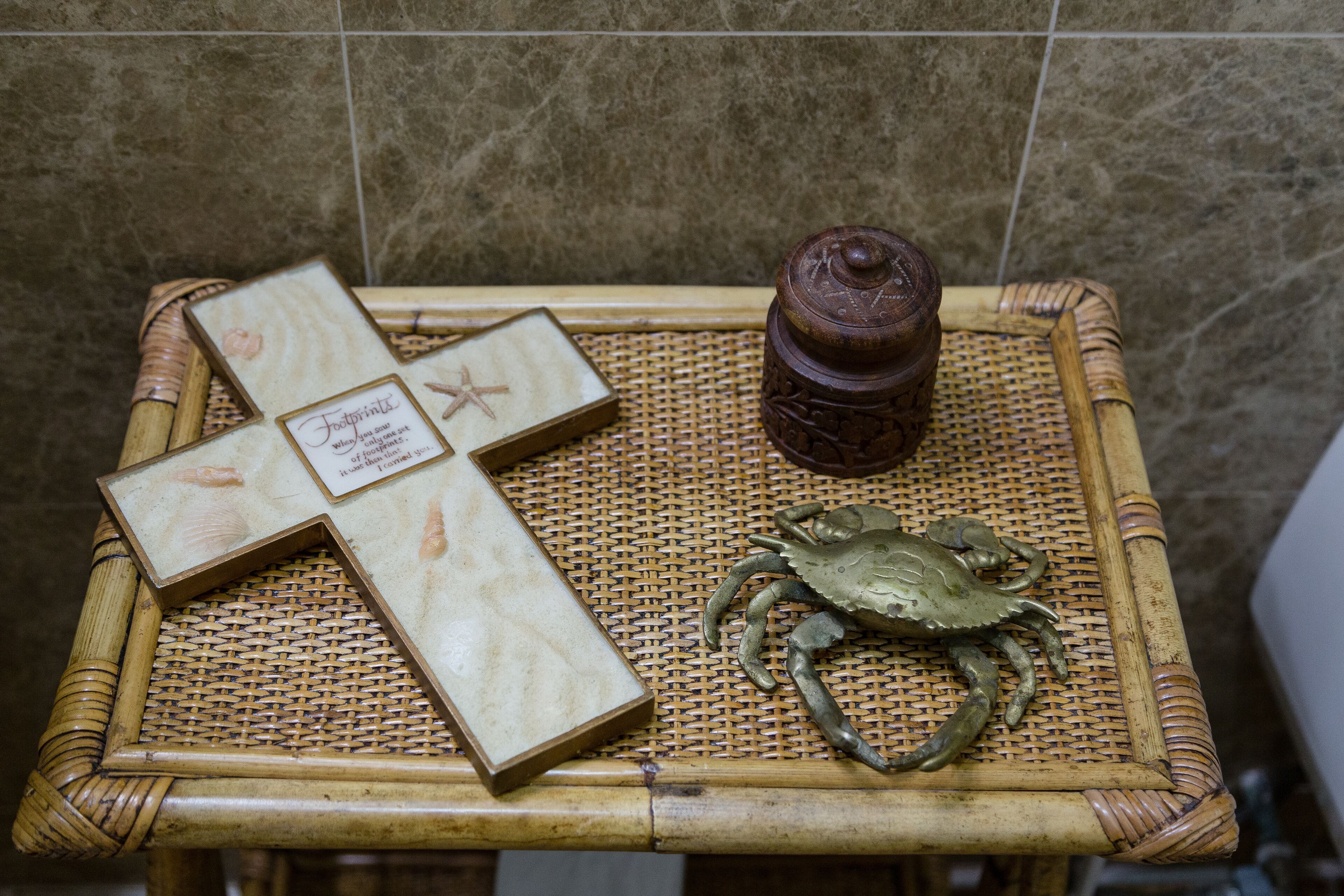 A wicker table with a crab figurine, a wooden box, and a small container.