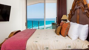 A bedroom with a large bed, a TV, and a view of the ocean. - Esmeralda Beach Resort 2 Bedrooms Condo B 502 (Puerto Peñasco)