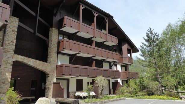 A multi-story building with wooden balconies and stone walls. - 3-room cabin apartment, south-facing balcony, 5 pers., private parking (Les Contamines-Montjoie)