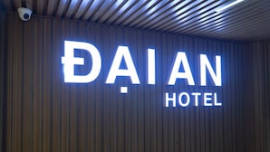 A sign for DAIAN HOTEL with a modern design and a security camera above it. - Dai An Binh Tan Hotel (Ho Chi Minh City)