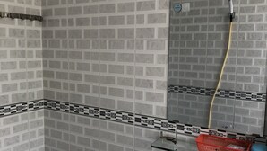 Ein Badezimmer mit Waschbecken, Spiegel und einer Dusche mit Duschschlauch.