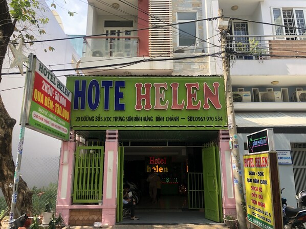A hotel named 'Hotel Helen' with a green signboard, a visible entrance, and a motorcycle parked outside. - Hotel An Nhi (Song Ma)