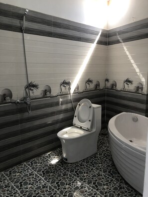 A bathroom with a toilet, a shower, and a bathtub. The walls have a striped pattern, and there are decorative vases on the wall.