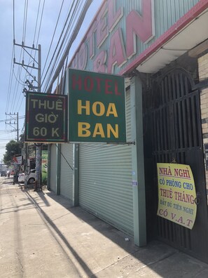A hotel sign with "HOTEL HOA BAN" and a digital display above it.