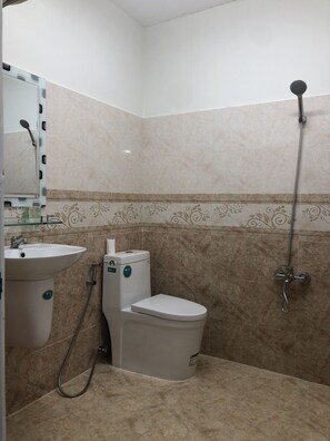 A bathroom with a sink, toilet, and shower. - Duc Linh Hotel (Phu Quoc)
