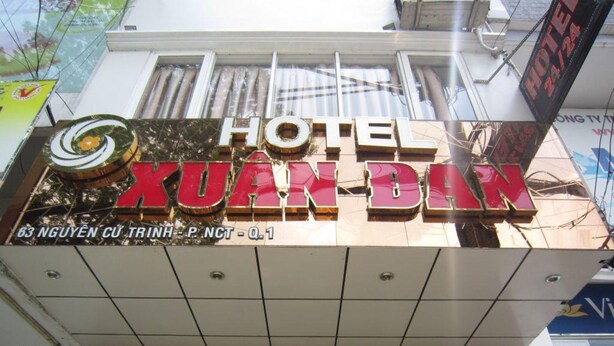 Un letrero de hotel con el nombre 'HOTEL XUAN DAN' y su dirección.
