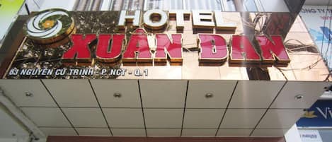 A hotel sign with the name "HOTEL XUAN DAN" and its address.