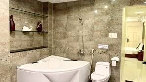 Ein modernes Badezimmer mit einer großen Badewanne, einer Toilette und einer Dusche.