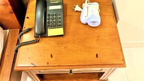 Ein Holztisch mit einem Wählscheintischtelefon und einem weißen Haartrockner.