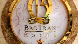 Eine Marmorplatte mit dem Logo des Baotran Hotels, inklusive einem stilisierten 'B' und einem Sternsymbol.