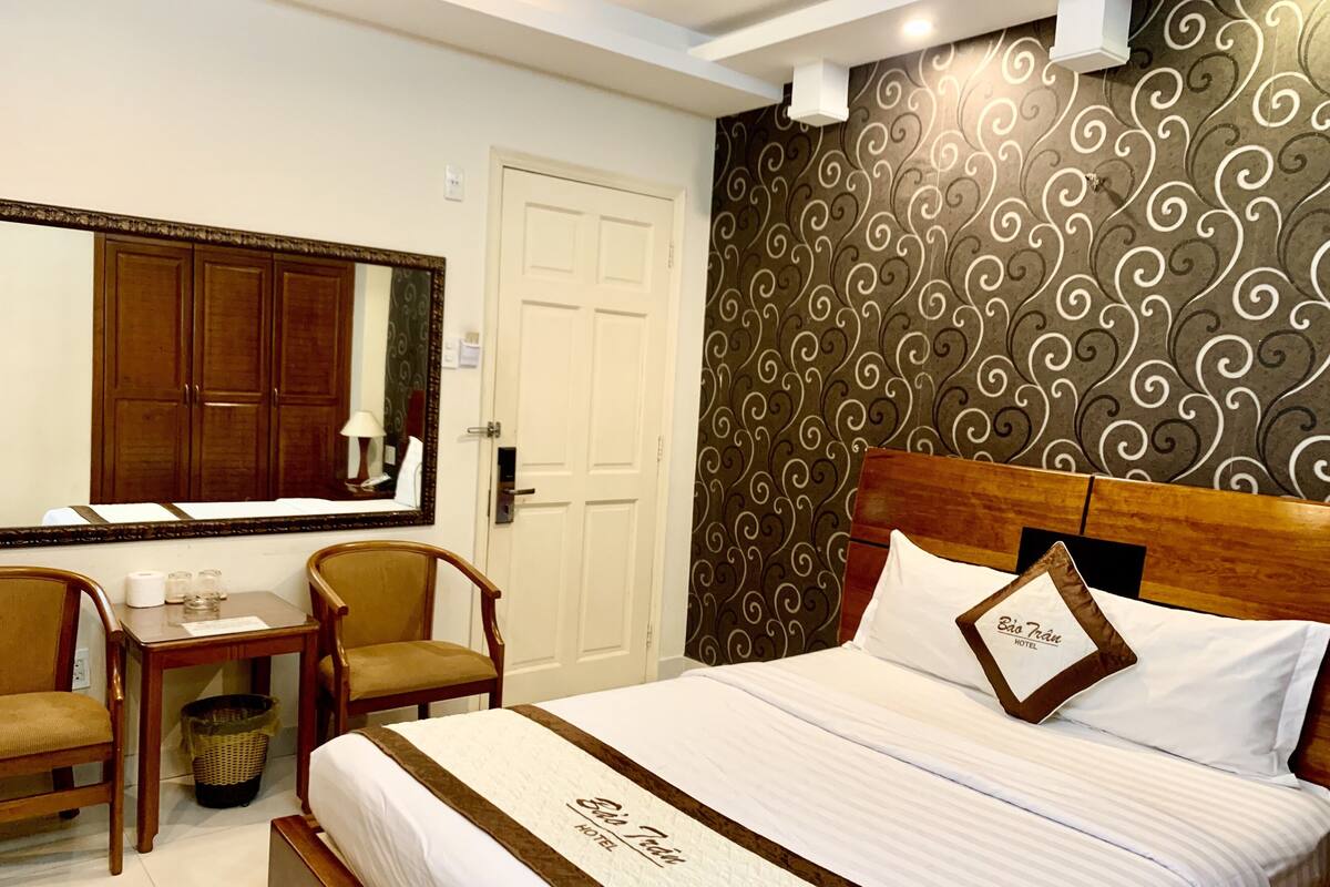 Ein Hotelzimmer mit Bett, Schreibtisch und Stuhl.