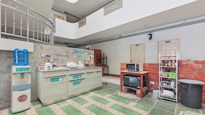 A kitchen with a water dispenser, a microwave, and a trash bin. - View Mansion (Chonburi)