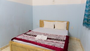 A single bed with a wooden headboard, white linens, and a patterned bedspread. - Ngoc Trinh Hotel Binh Tan (Ho Chi Minh City)