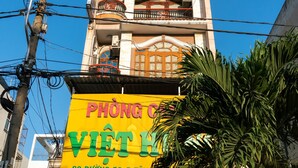 Un edificio con un gran letrero amarillo que anuncia un hotel.