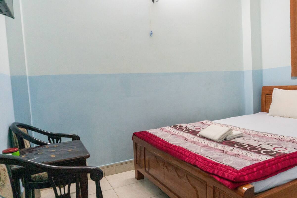 Ein Zimmer mit einem Bett, einem Sessel und einem kleinen Tisch.