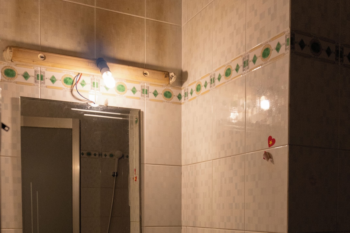 A bathroom with a sink, mirror, and shower.