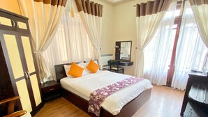 A hotel room with a bed, a desk, a chair, and a mirror. - Nhat Huy Hotel (Xuan Huong - Da Lat)