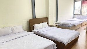 A hotel room with three single beds, wooden headboards, and a large window with curtains. - Sao Mai Tim Hotel (Xuan Huong - Da Lat)