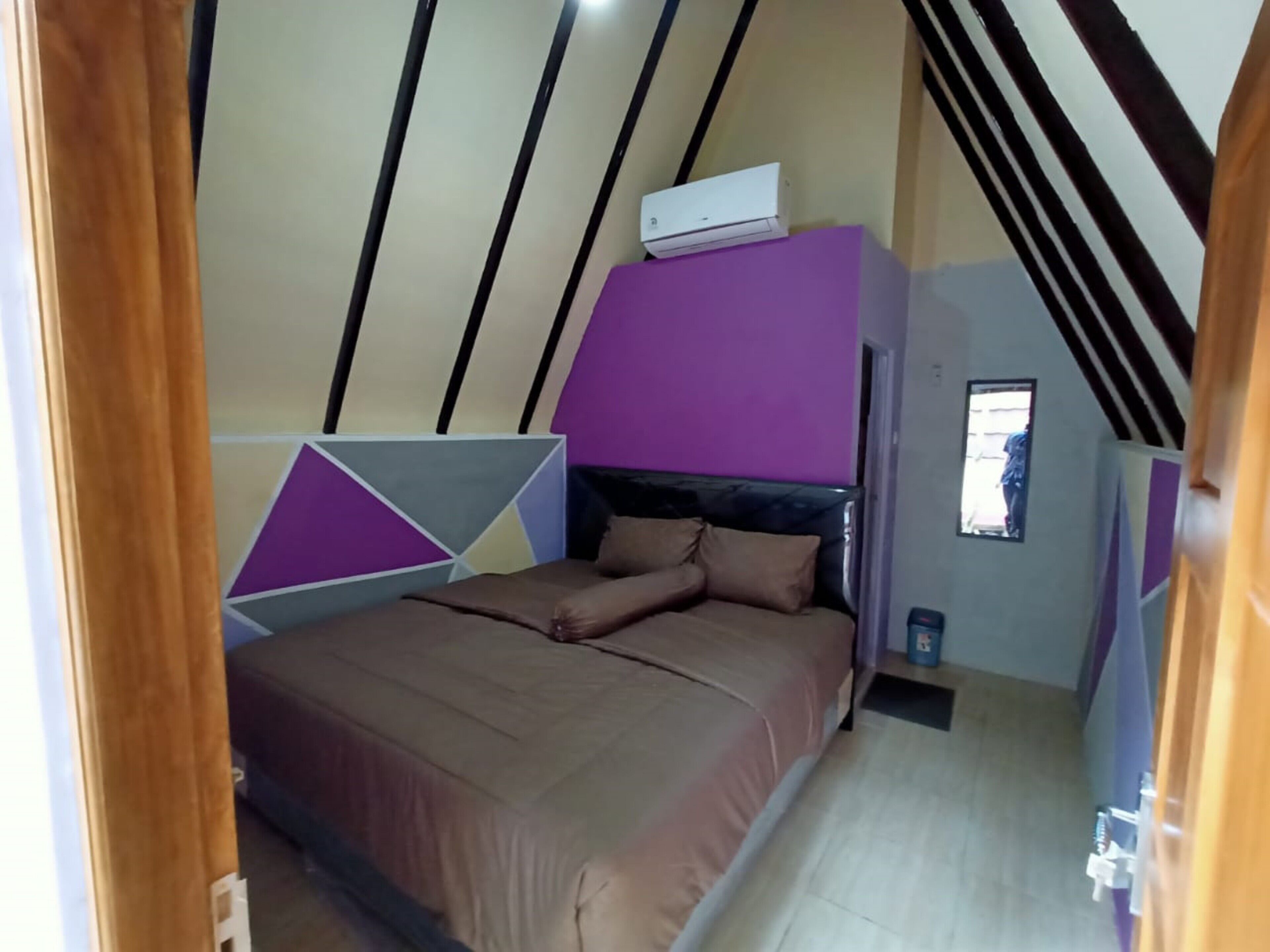 A bedroom with a bed, a window, and a ceiling fan.