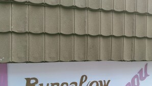 Een bord met de tekst 'Bungalow' en een gedeeltelijk woord dat 'ungu' lijkt.
