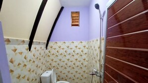 Een kleine badkamer met toilet, douche en een behangen muur.