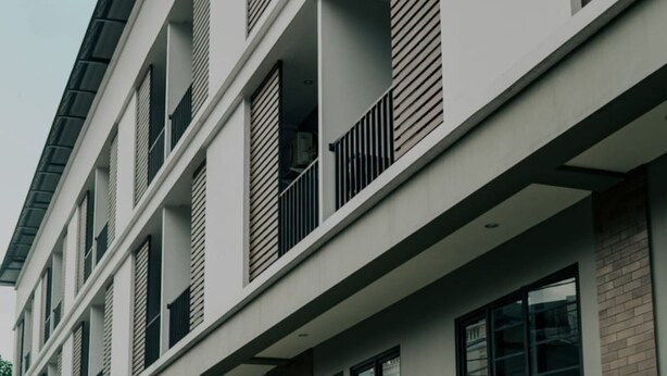 A modern multi-story building with balconies, large windows, and a concrete base. - Mendjangan Residence (Jakarta)