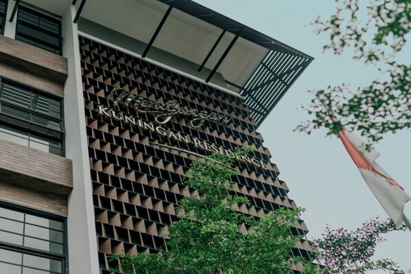 A building with a modern facade featuring a geometric pattern and the name "Klinggan Residence".