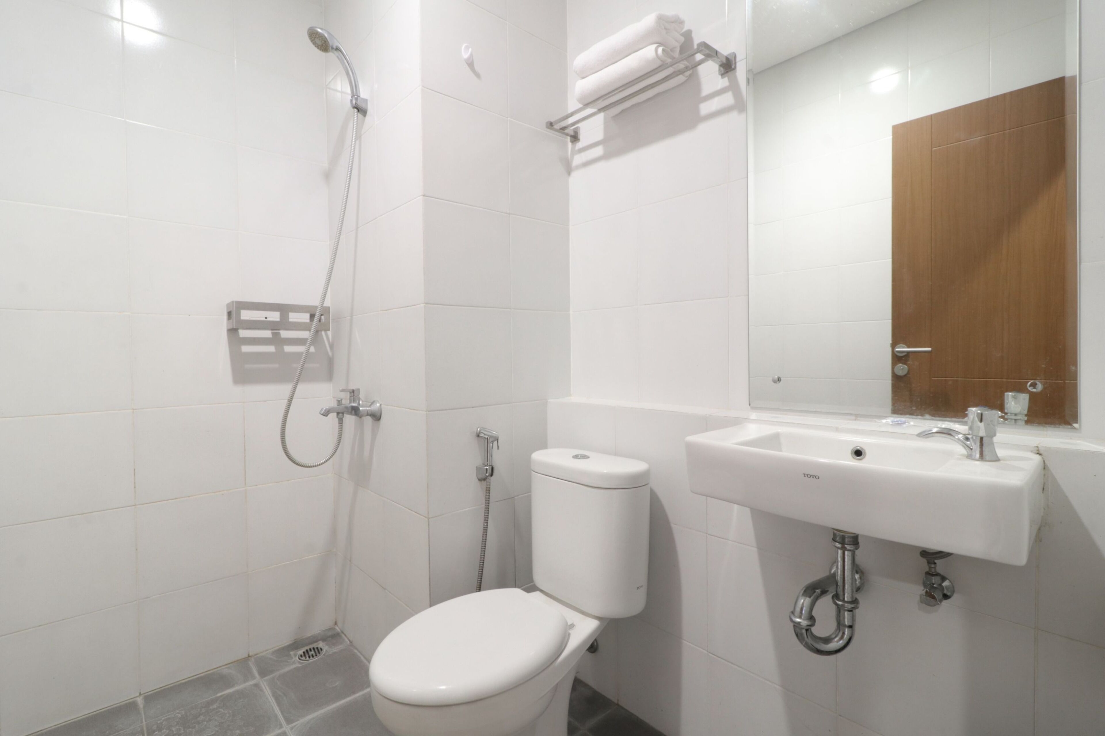 A modern bathroom with a toilet, shower, and sink.