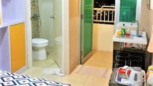 A compact bathroom with a toilet, a shower area, and a sink with toiletries. - Apartement Educity Tower Y-P-H By Prafi (Surabaya)