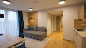 Un apartamento moderno con sala de estar, kitchenette y comedor.