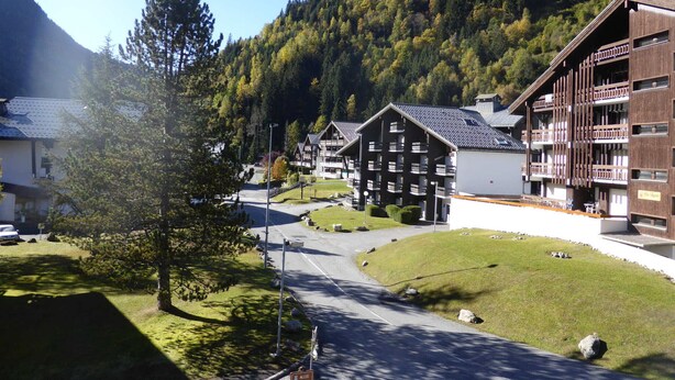 Eine Berglodge mit mehreren Chalets, einer asphaltierten Straße und bewaldeter Landschaft.