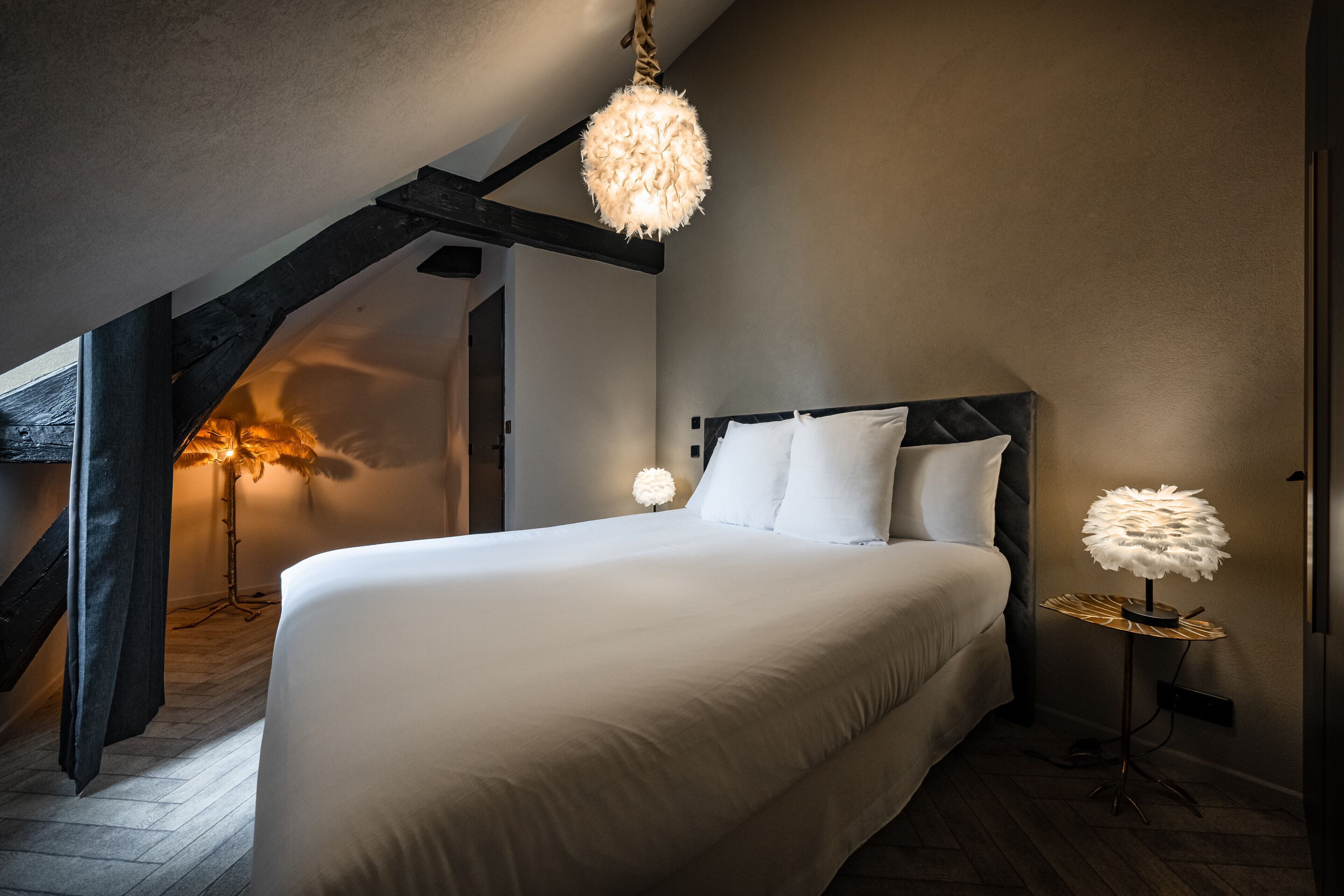 Un dormitorio con una cama grande, una lámpara colgante y una lámpara de pie.