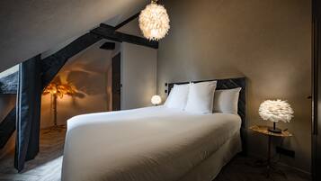 Un dormitorio con una cama grande, una lámpara colgante y una lámpara de pie.