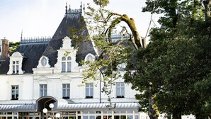 A large, historic building with a symmetrical facade, large windows, and a covered outdoor seating area. - Le Chateau de Maubreuil (Carquefou)
