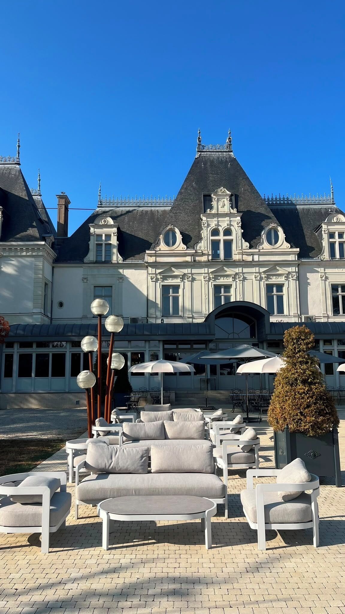 Un bâtiment à la façade symétrique, doté de grandes fenêtres et d’une entrée centrale surmontée d’une arche décorative.