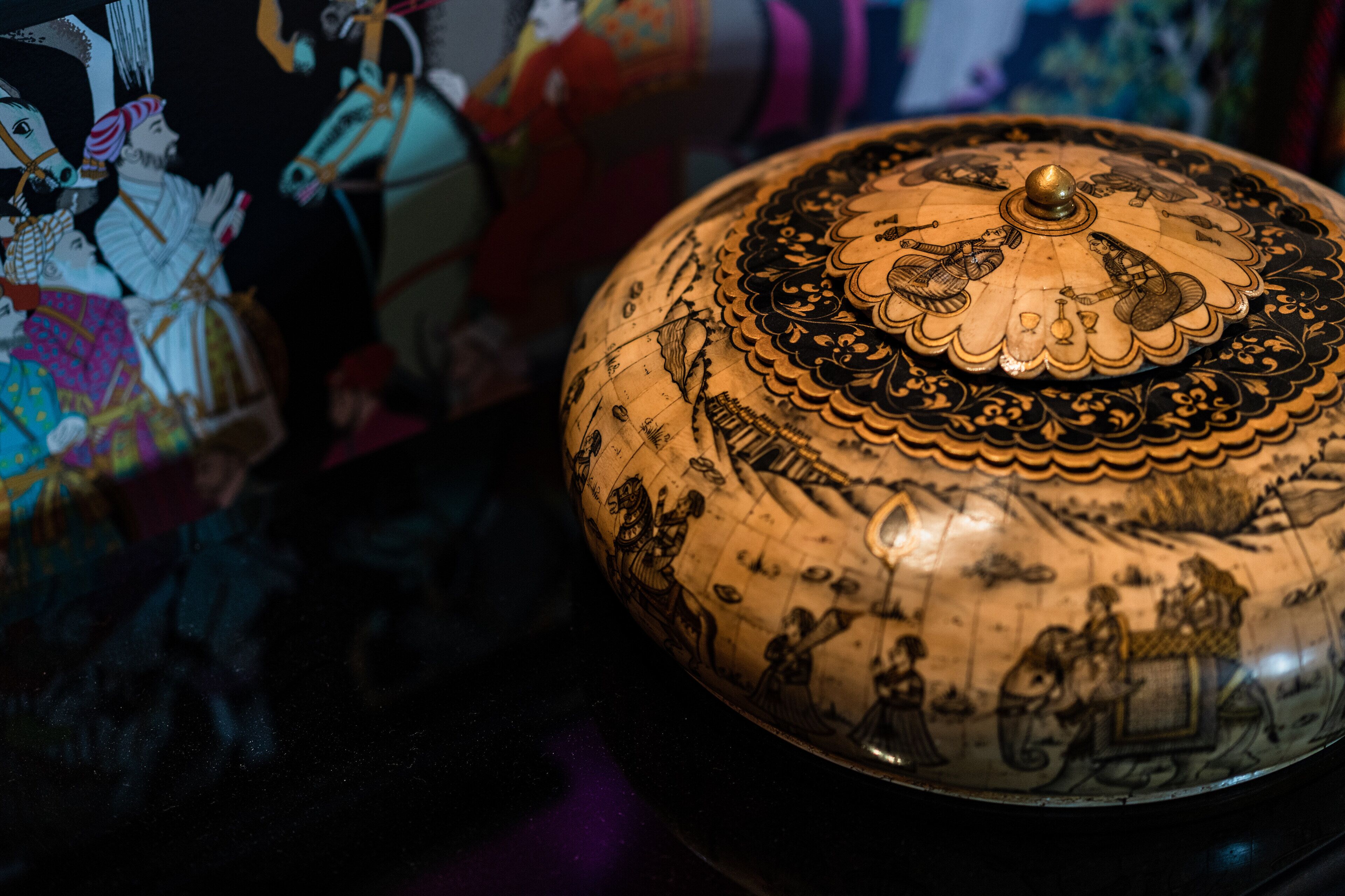 Un globe décoratif orné de motifs complexes et surmonté d’un élément ornemental central.