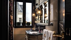 A narrow, dark-toned bathroom with a large window, a wooden vanity, and a mirror above it. - Le Chateau de Maubreuil (Carquefou)