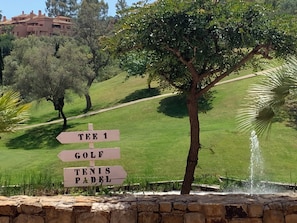A signpost with directions to Tee 1, Golf, and Tennis Padel.