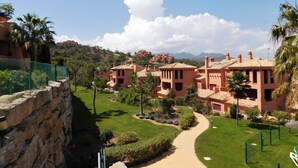 A resort with multiple buildings, a well-maintained lawn, and a clear sky.