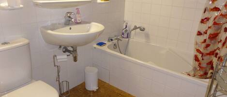 Un baño con inodoro, lavamanos y bañera.