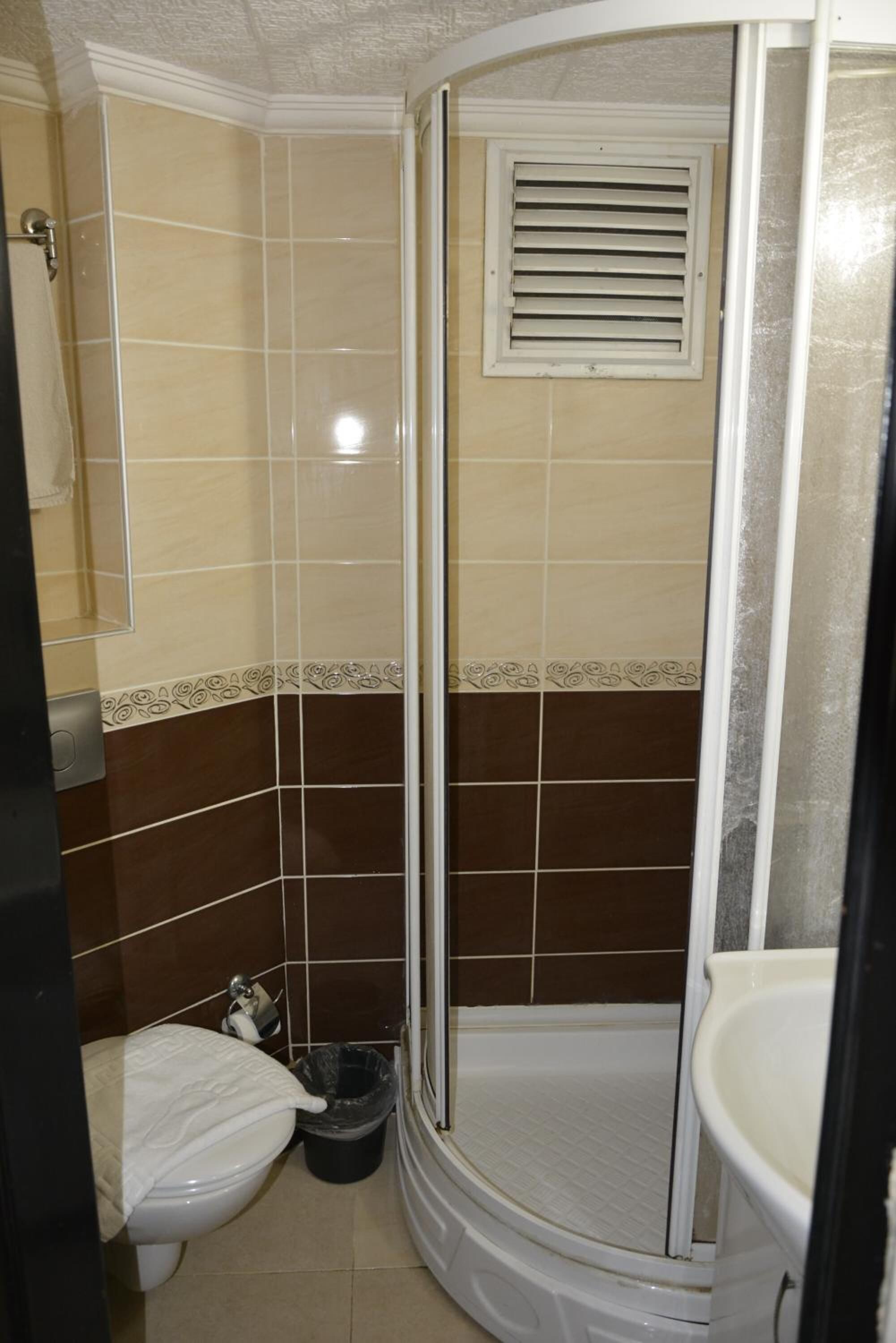 A small, enclosed bathroom with a shower, toilet, and sink.