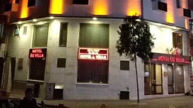A multi-story hotel with illuminated windows and a sign reading "HOTEL DE VILLA". - Hotel Oz Villa (Istanbul)
