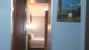 A narrow hallway leading to a room with a bed, a wall-mounted light, and a framed picture of a building labeled "TURKEY". - Hotel Oz Villa (Istanbul)