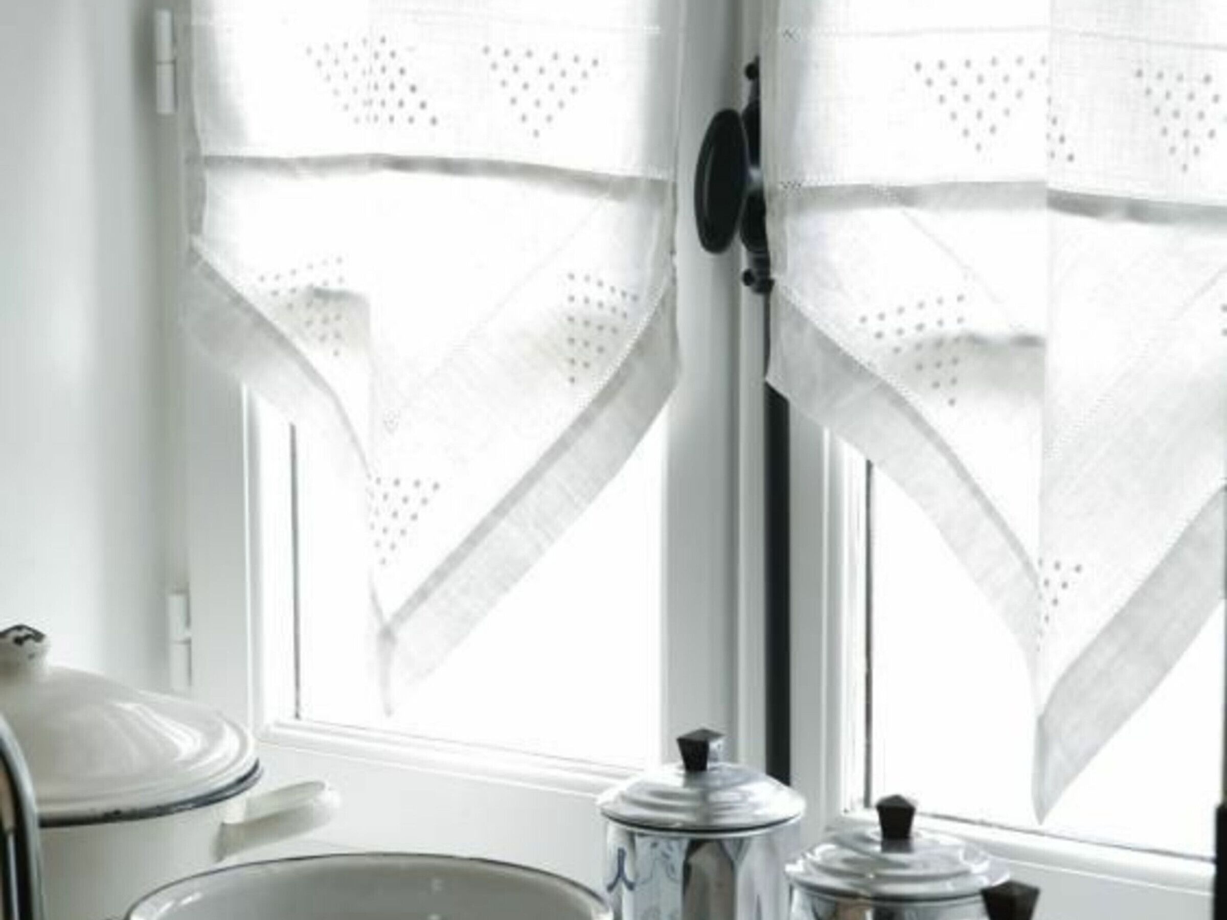 Una cocina con ventana, estufa y pileta.