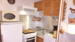 Una cocina compacta equipada con microondas, estufa, horno y lavavajillas.